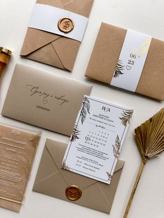 the wedding stationery is laid out on top of each other, including envelopes and cards