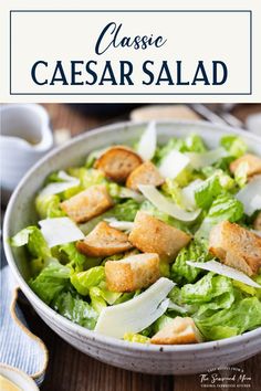 a salad with croutons and parmesan cheese on top in a bowl