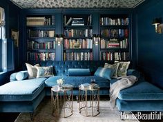 an image of a living room with bookshelves on the wall and blue couches