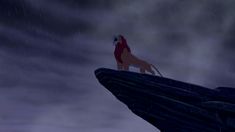 the lion king standing on top of a cliff in the rain with his head down