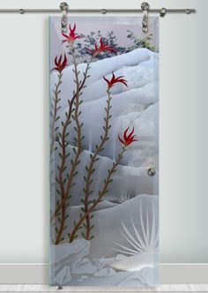 a glass door with red flowers and birds on the snow covered ground in front of a window