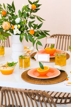 the table is set with oranges and plates