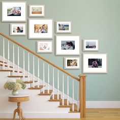 a staircase with pictures on the wall and a table in front of it, along with a vase filled with flowers