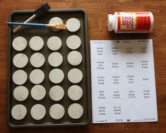 an empty tray with white circles and paint next to a receipt on a wooden table