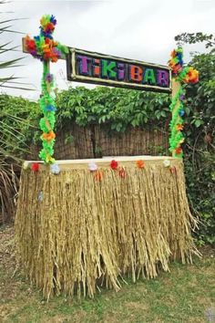 a tiki bar decorated with grass and flowers