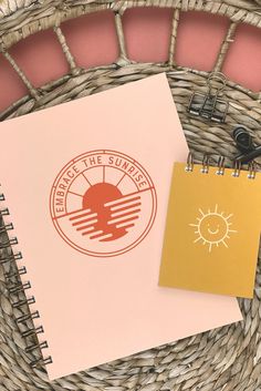 a spiral notebook sitting on top of a wicker basket next to a clipboard