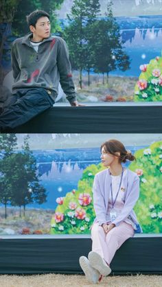 two people sitting on top of a bench in front of a wall with flowers painted on it