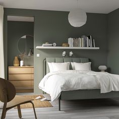 a bedroom with green walls and white bedding