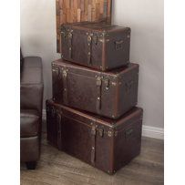 three suitcases stacked on top of each other in front of a brown leather chair