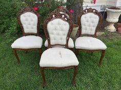 four antique chairs sitting in the grass