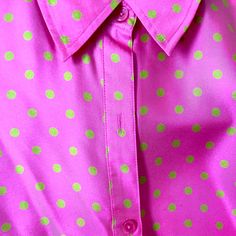 a pink shirt with green polka dots on it