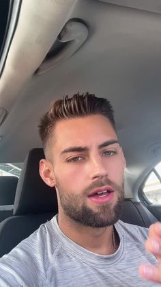 a man sitting in the back seat of a car with his hand out to someone