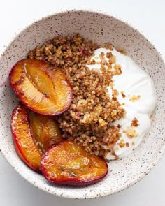 a bowl filled with fruit and yogurt on top of a white tablecloth