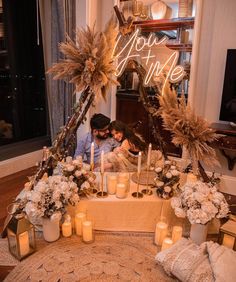 two people sitting at a table surrounded by candles