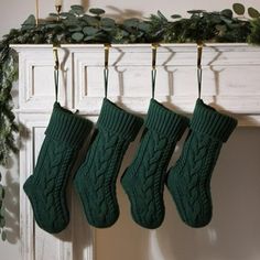 three green socks hanging from a mantel