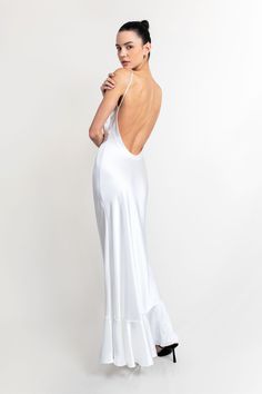 a woman in a white dress with her back to the camera