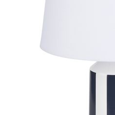 a white and black lamp with a white shade on it's side, against a white background