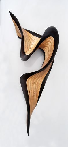 two pieces of art made out of wood on a white surface with black and gold details