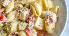 a white bowl filled with pasta salad on top of a table