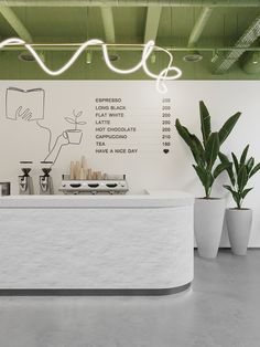 a white counter sitting next to two potted plants