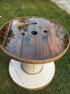 a wooden table sitting on top of a green grass covered field with holes in it