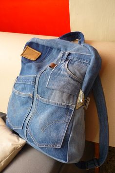 a blue jean purse sitting on top of a white bench next to a red wall