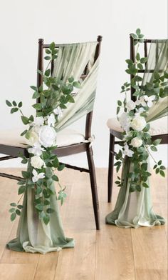 two chairs decorated with flowers and greenery