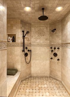 a walk in shower sitting next to a tiled wall and floor with two lights on the ceiling