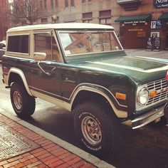 a green and white truck parked on the street