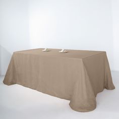 a table with two plates on it in front of a white wall and an empty chair