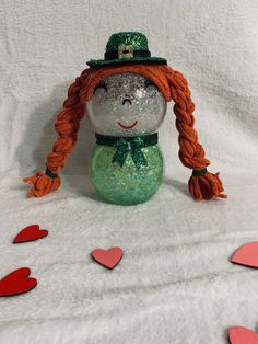 "Handcrafted glass lighted Girl Leprechaun.  Made out of glass bubble vases.  LED fairy lights will illuminate the body of the character.  Lights have 8 different modes, brightness adjustment. and timer.  The battery pack is accessible from behind the character to allow battery replacement.  Remote for lights and batteries are included.  Approx 9\" x 4\"." Girl Leprechaun, Fishbowl Craft, Bubble Vases, Dollar Tree Diy Home Decor, Dollar Tree Easter Crafts, Diy Home Decor Ideas, Glass Bubble, Led Fairy Lights, Diy Dollar Store Crafts