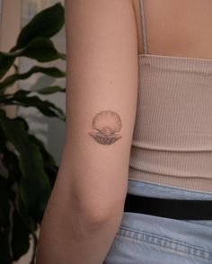 a woman's arm with a small tattoo on the back of her left arm