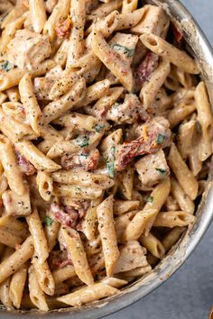 a bowl full of pasta with meat and sauce on top, sitting on a table