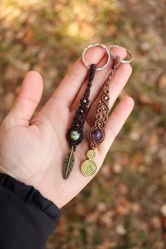 a hand holding three different types of key chains