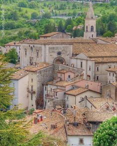 an aerial view of old buildings in the countryside with trees and hills behind them,