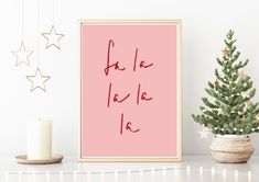 a pink poster with the word love written on it next to a small christmas tree