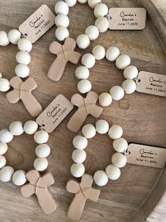 some white and brown beads are on a wooden tray with tags that read, wedding date