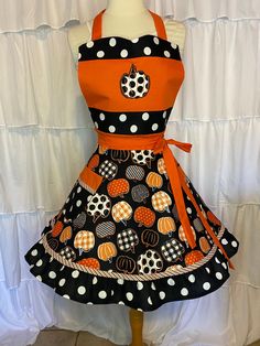 a mannequin wearing an orange and black polka dot dress