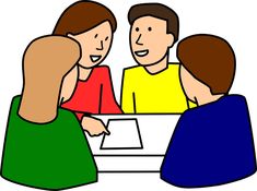 three people sitting at a table talking to each other, with one person holding the other's hand