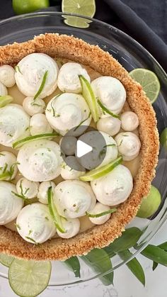 an overhead view of a pie on a plate with limes and other food items