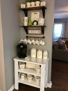 a coffee bar with cups and mugs on the shelves above it is in a living room