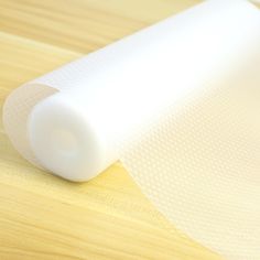 a roll of white mesh sitting on top of a wooden table