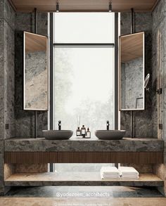 a bathroom with two sinks and mirrors in front of a large window that looks out onto the woods