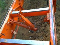 the back end of an orange truck with metal bars attached to it's sides