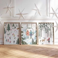 three framed art pieces with people skiing and snowflakes hanging from the ceiling