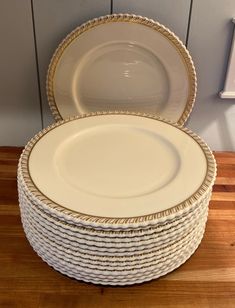 a stack of white plates sitting on top of a wooden table