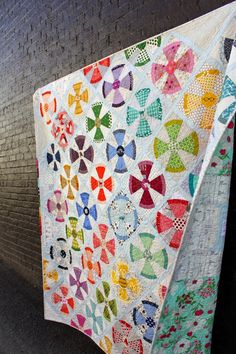 a colorful quilt hanging on the side of a building