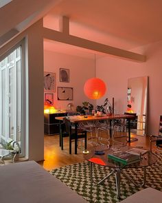 a living room filled with furniture and a large window covered in bright orange light bulbs