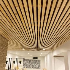 a living room filled with lots of furniture and wooden slats on the ceiling above