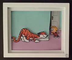 a paper cut out of a cartoon character and a cat laying on the ground in front of a door